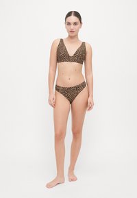 Leopard print bikini set in brown and black; features a v-neck bralette top and matching low-rise bottom, made from soft, textured material.