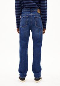 Spijkerbroeken met een rechte pijp, medium wassing, voorzien van twee achterzakken en een bruine leren patch op de tailleband.