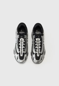 Black and silver athletic sneakers with mesh and synthetic material, featuring a lace-up design, rounded toe, and textured accents.