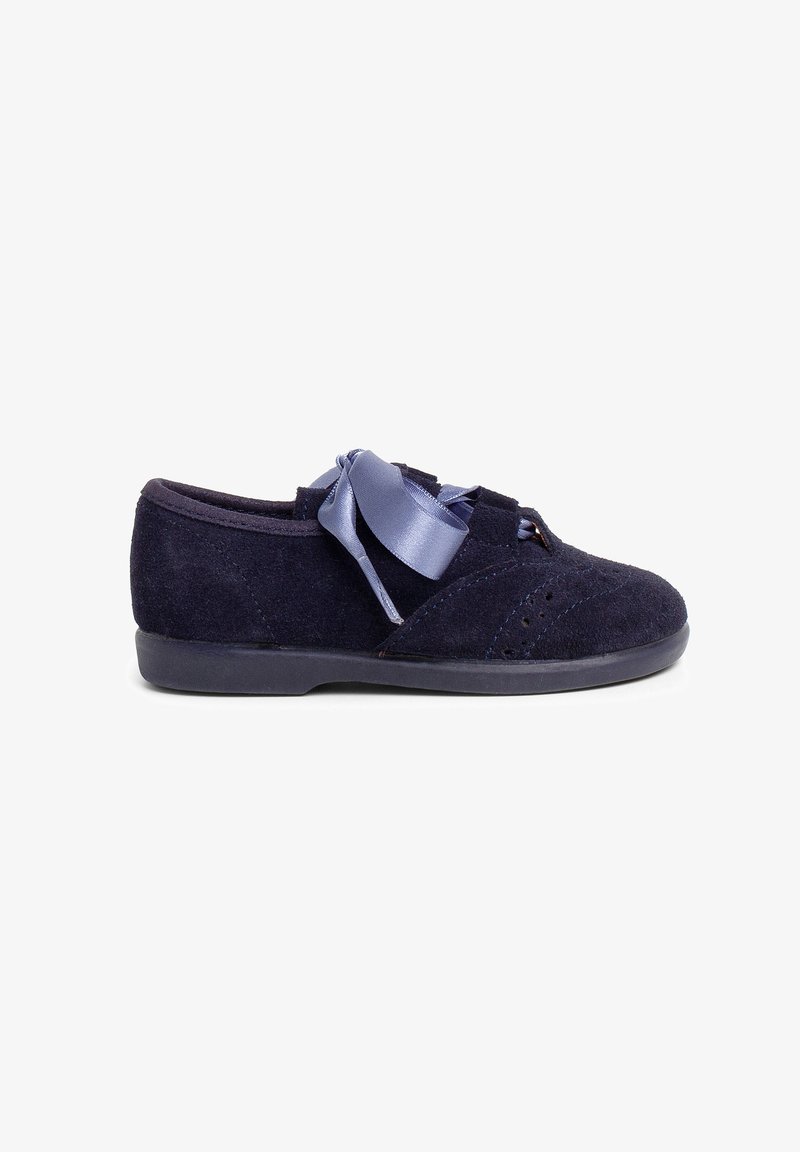 Scarpa in suede blu navy con punta rotonda, caratterizzata da un laccio in raso e dettagli perforati sulla tomaia. Design con suola piatta per un comfort ottimale.