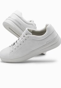 Weiße Sneaker aus Wildleder, mit runder Spitze, Schnürverschlus und strukturiertem Gummi-Außensohle mit Profilmuster.