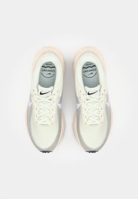 Lichtgroene sportschoenen met een bovenwerk van mesh, een gestructureerde oppervlakte, witte accenten en dikke, crèmekleurige zolen. Voorzien van veters en een logo.