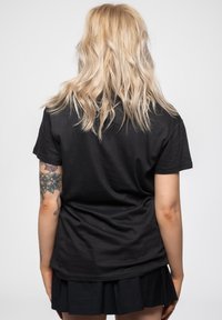 Black cotton t-shirt viewed from the back, featuring a relaxed fit and short sleeves. No visible patterns or accents.