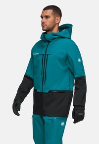 Türkis-schwarze wasserdichte Jacke mit Kapuze, Reißverschlusstaschen und verstellbaren Kordeln. Mit Logodetails und einem eleganten Design.