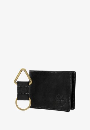 Portafoglio in pelle nera con cuciture bianche e logo in rilievo. Include un portachiavi staccabile con hardware in ottone e design a clip triangolare.