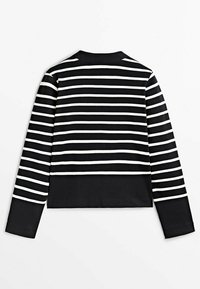 Czarna i biała w paski krótka kurtka z długimi rękawami, z okrągłym dekoltem i gładką teksturą. Brak widocznych zapięć lub ozdób.