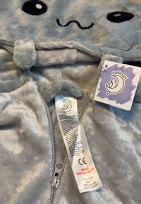 Grau Plüsch-Hoodie mit Tiergesicht-Design, mit Reißverschluss und einem Etikett. Weicher Stoff mit runden Ohren und gestickten Augen.