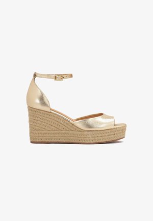 Sandale compensée ouverte dorée avec bride à la cheville et boucle, dotée d'une semelle plateforme en jute tressé.
