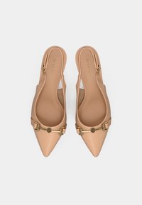 Γόβες slingback σε απαλό γυμνό χρώμα με μυτερή μύτη και μικρή χρυσή αγκράφα. Λείο υλικό με σχεδιασμό κοπής και χαμηλό τακούνι για άνεση.