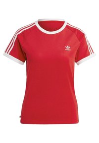 Czerwona koszulka sportowa z białym ściągaczem przy okrągłym dekolcie i rękawach, trzema białymi paskami na ramionach oraz małym białym logo na piersi.