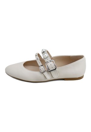 Zapato Mary Jane de cuero blanco plano con dos correas con hebilla, una adornada con cuentas decorativas similares a perlas, y una suela baja marrón.