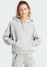 Sweat à capuche gris avec des rayures blanches, poches avant et cordon de serrage ajustable. Fabriqué dans un tissu doux et texturé, mettant en valeur un détail de logo.
