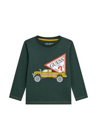 Camicia verde a maniche lunghe con accenti gialli, con una grafica di un camion giallo e un logo triangolare rosso con la scritta “GUESS?”. Realizzata in morbido cotone.