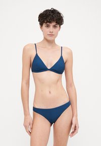 Set di bikini a coste blu scuro composto da un top triangolare con spalline sottili e slip a vita bassa coordinati. Tessuto liscio con un design adattato.