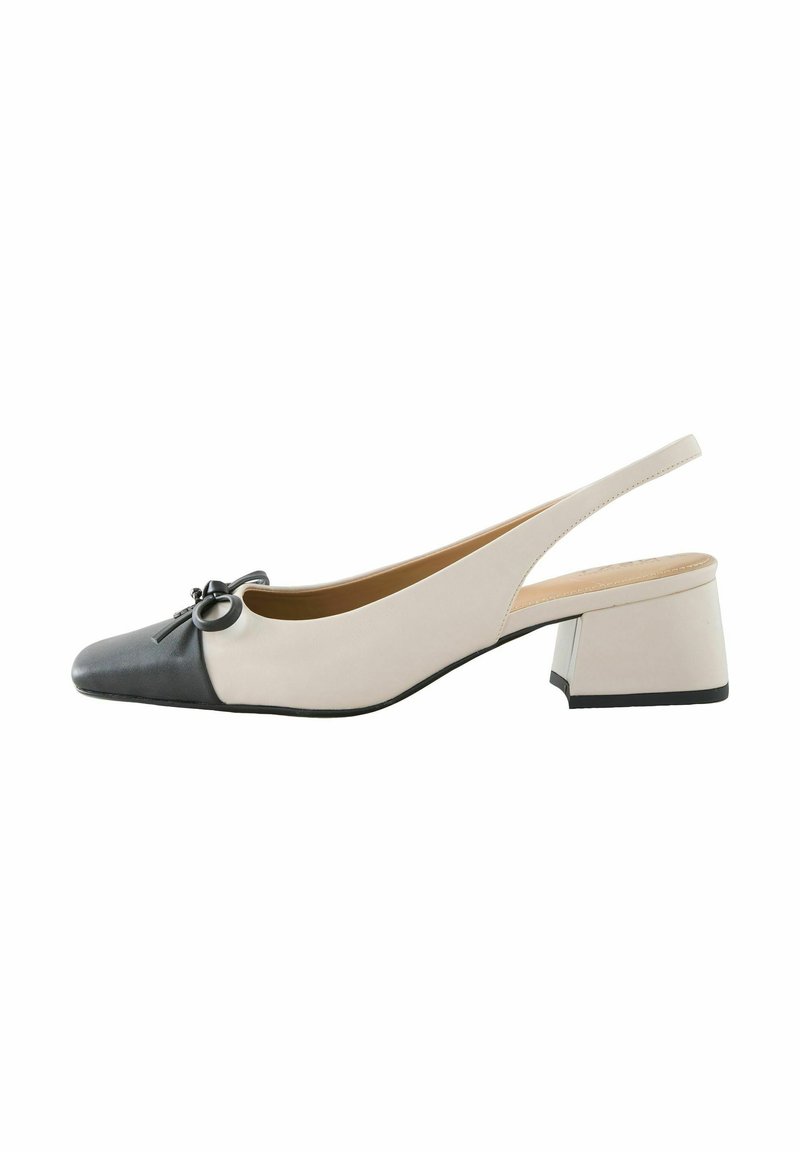 Zapato slingback con punta afilada, diseño bicolor: parte frontal negra y parte trasera beige, con un lazo decorativo y un tacón bajo de bloque.