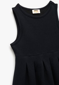 Schwarzes ärmelloses Kleid aus weichem, strukturiertem Stoff. Es hat einen runden Halsausschnitt und ein plissiertes Saaldesign, mit einem Etikett "Koton Kids".