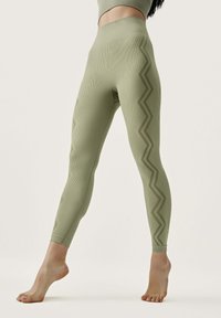 Light green leggings featuring a ribbed texture and zigzag pattern along the sides, with a high waistband and ankle-length design.