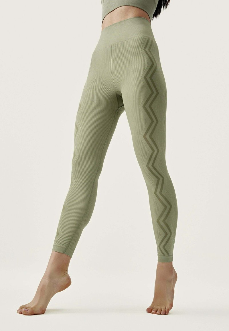 Light green leggings featuring a ribbed texture and zigzag pattern along the sides, with a high waistband and ankle-length design.
