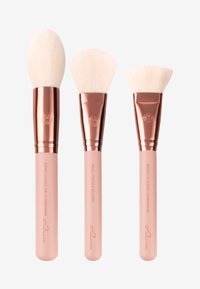 Juego de tres brochas de maquillaje con suaves cerdas blancas, virolas de oro rosado y mangos rosas. Incluye formas para diferentes técnicas de aplicación.