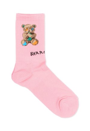 Roze sok met een gepixelde teddybeer met blauwe en oranje vlekken en gedeeltelijk zichtbare zwarte tekst nabij de enkel.