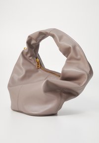 Měkká taška ze taupe kůže s uzlem na rukojeti, má zipový uzávěr se zlatými detaily a volnější design. Hladký povrch, minimální prošívání.