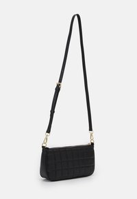 Borsa a tracolla in pelle trapuntata nera con tracolla regolabile e zip e ganci in metallo dorato, esposta su uno sfondo bianco.