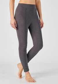 Leggings grises con un acabado texturizado, que cuentan con una cinturilla alta y detalles de costura sutiles, diseño ajustado y un puño en el tobillo con brillo.