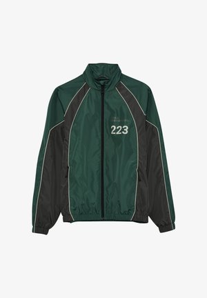 Zielono-czarna sportowa kurtka na zamek z wysokim kołnierzem, elastycznymi mankietami, bocznymi kieszeniami oraz nadrukiem numeru "223" na piersi.