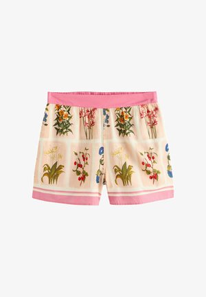 Hellrosa Shorts mit roten, blauen und grünen Blumenmustern und einem einfarbigen pinken Bund, getragen im Freien vor grünem Laub.