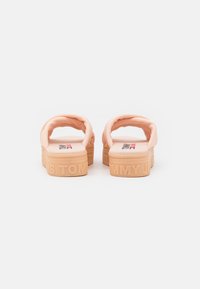 Sandali platform color pesco con cinturini imbottiti, suole in gomma e nome del marchio impresso sul tallone. Materiale testurizzato per il comfort.