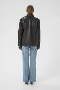 Black leather jacket with a structured design, featuring a high collar, shoulder epaulets, and zipper accents, paired with light blue jeans.