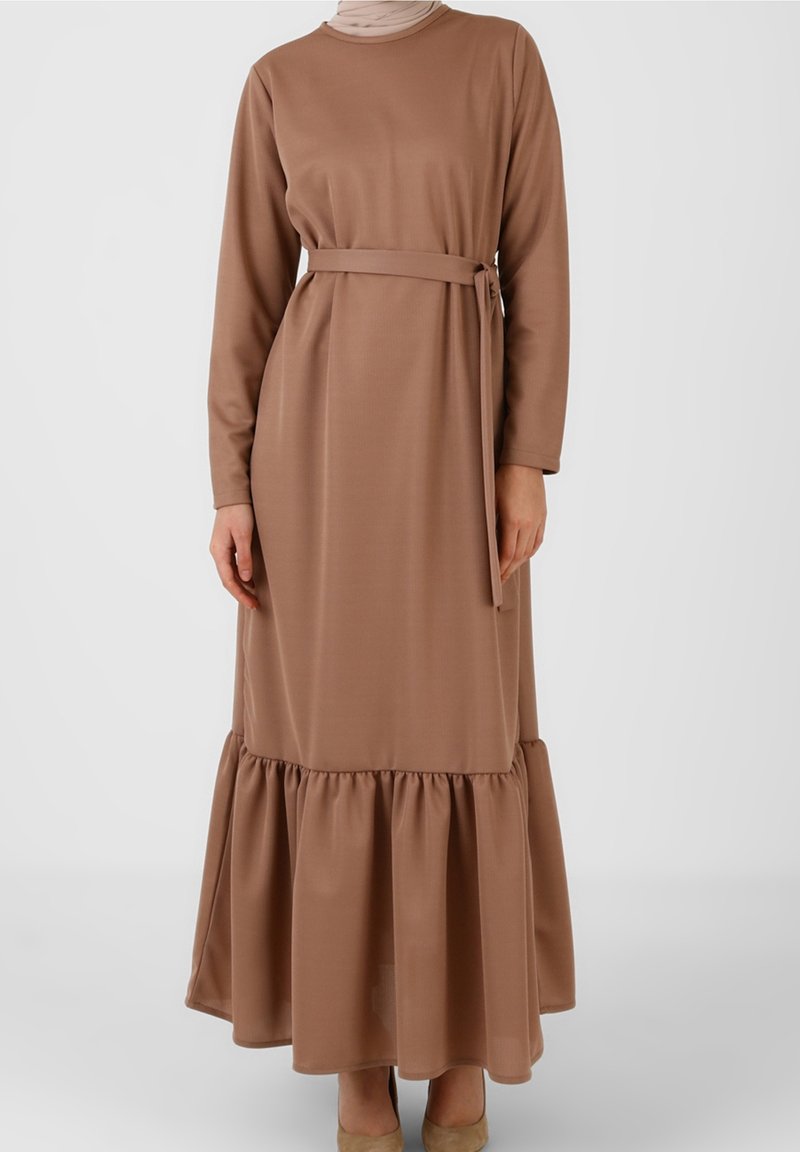 Robe longue marron en tissu doux, avec manches longues, ceinture à nouer à la taille, et ourlet à volants à étages.