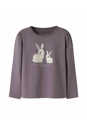 Chemise pour enfants à manches longues violette avec épaules bouffantes, avec un motif imprimé de deux lapins blancs et un texte sur le devant.
