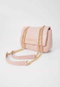 Κουβερτίνα ροζ δερμάτινη τσάντα χειρός με χρυσή αλυσίδα και λουρί. Διαθέτει καπάκι που διπλώνει και ανάγλυφο λογότυπο στο μπροστινό μέρος. Συμπαγής και δομημένος σχεδιασμός.