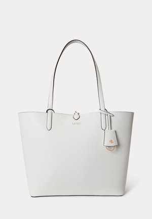 Λευκή δερμάτινη τσάντα ώμου με δύο μακριές λαβές, υφή στην επιφάνεια, μικρό χρυσό λογότυπο και ένα κρεμαστό δερμάτινο ταμπελάκι με χρυσά μεταλλικά στοιχεία.