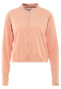 Chaqueta deportiva de manga larga en rosa claro con cremallera frontal completa y pequeño logo reflectante de Nike en el lado izquierdo del pecho.