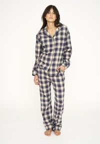 Navy og creme ternet flannel pyjamasæt med knap-op langærmet top og lange bukser med sidelommer og en afslappet pasform.