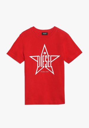 Rød t-shirt med korte ærmer med hvid stjerne-grafik og teksten "DIESEL" inde i stjernen, lille globus-ikon og sloganet "FUTURE is NOW" nedenunder.