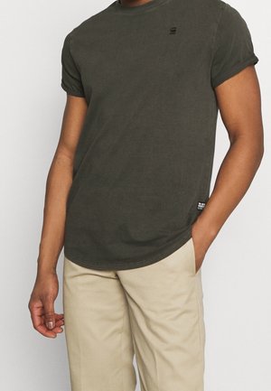 Tumma vihreä puuvillapaita, jossa on lyhyet hihat, pyöreä kaula-aukko ja pieni logo rinnassa; sisältää suoran helman ja rentoa istuvuutta.