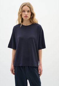 Tengerészkék, oversized pamut póló rövid ujjakkal és kerek nyakkivágással, sima tapintással és laza szabással.