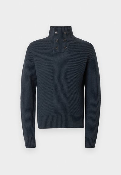 Tummansininen neulottu villapaita, jossa on korkea kaulus ja neljä nappidetalja, samoin kuin ribbitekstuuri sekä käärme- ja helmaosat ovat istuvia.