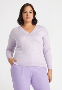 Hellblauer V-Ausschnitt-Pullover mit strukturiertem Blumenmuster und langen Ärmeln, kombiniert mit passenden hellblauen Hosen. Aus weichem Strickmaterial.