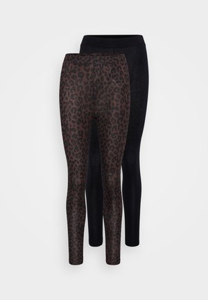 Két leggings pár: az egyik fekete, a másik leopárd mintás, barna foltokkal sötét háttéren. Mindkettő testhezálló és sima textúrájú.