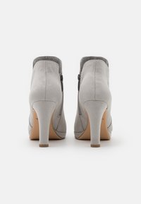 Gray suede ankle boots with a high heel, featuring a side zip closure and a smooth texture. The design has a rounded toe and minimal accents.