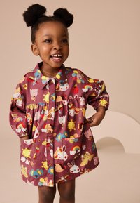 Vestito color marsala con motivi colorati di animali e fiori in stile cartone animato, chiusura frontale con bottoni e tasche. Maniche lunghe con polsini elastici.