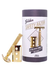 Guldsäkerhetsrakkniv med ett texturerat metallhandtag, guldfinish och ett extra huvuddock. Förpackad i en cylindrisk pappbehållare.
