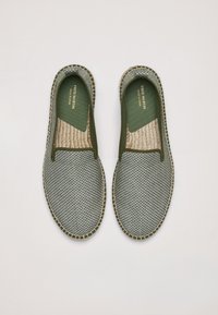 Zapatos slip-on a cuadros verdes y grises con tejido texturizado, plantillas de yute y costuras en contraste a lo largo de los bordes. Diseñados para uso casual.