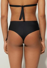 Černé bikini kalhotky s vysokým pasem a nastavitelnými bočními šňůrkami. Hladká textura, minimální zakrytí a klasický střih.