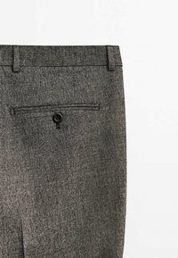 Graue karierte Hose mit flacher Vorderseite, einer Gesäßtasche mit schwarzem Knopf und einem maßgeschneiderten Schnitt. Der Stoff wirkt strukturiert und gewebt.