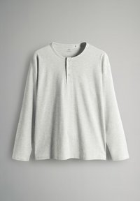 Camisa henley de manga larga en gris claro, fabricada en una tela suave, con cuello redondo, placket de tres botones y corte recto en el dobladillo.